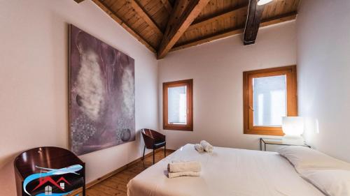 a bedroom with a white bed and a chair at Au Nom de la Rose in Venice