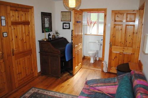 uma sala de estar com um piano e um WC em Boluisce em Glenbeigh