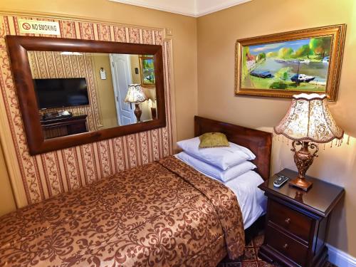 um quarto de hotel com uma cama e um espelho em Riverside Inn em Ely