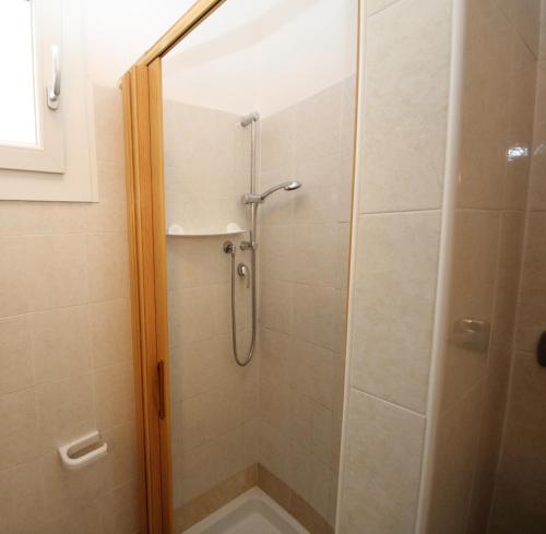 een douche met een glazen deur in de badkamer bij Arianna 01 in Rosolina Mare