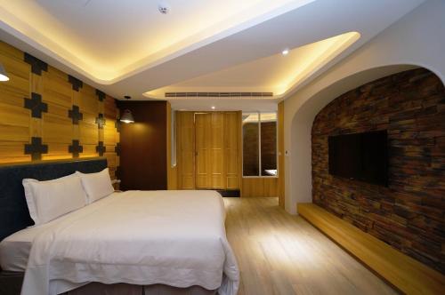 a bedroom with a bed and a brick fireplace at 浪琴Motel文創旅館 in Taichung