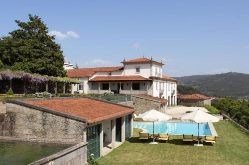 a villa with a swimming pool and a house at Casas do Monte de Roques in Vila de Punhe