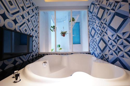 a bath tub in a bathroom with a window at 浪琴Motel文創旅館 in Taichung