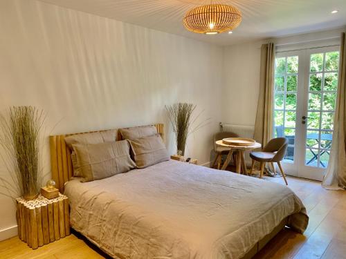 een slaapkamer met een bed en een tafel met stoelen bij Villa d'hôtes Graine de Pin in Le Touquet-Paris-Plage