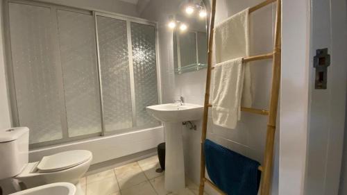 Un baño blanco con lavabo e inodoro. en Lusitania T2 Frente Mar em Quarteira, en Quarteira