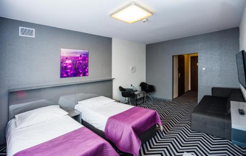 a hotel room with two beds and a tv at Hotel Wyspiański in Krakow