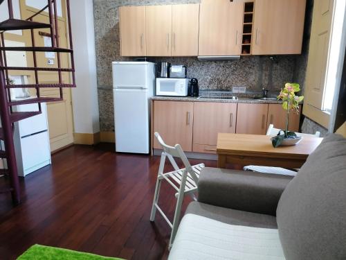 a kitchen with a couch and a table and a refrigerator at 4-As center apartments in Guimarães