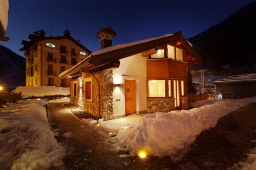 una pequeña casa en la nieve por la noche en Chalets Mignon en Limone Piemonte