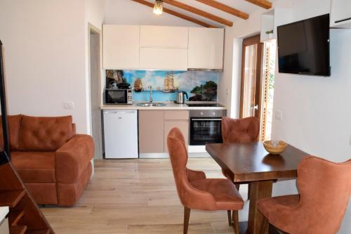 a kitchen and living room with a table and chairs at Apartments ELA in Piran