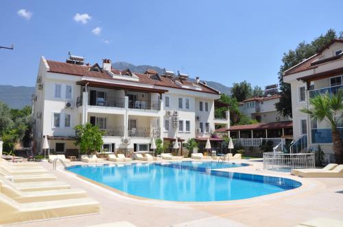 un hôtel avec une piscine en face de certains bâtiments dans l'établissement Tayfun Apart Hotel, à Ölüdeniz