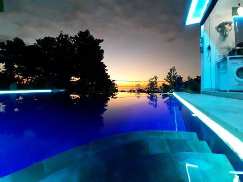 a swimming pool with a sunset in the background at Cantik Villa Tugu Belanda in Lovina