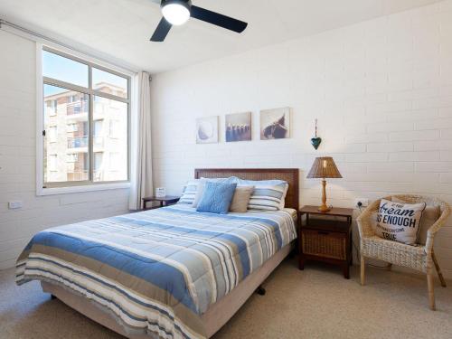 a bedroom with a bed and a window and a chair at Little Hut 1 Spectacular Water Views NBN and Air Conditioned in Nelson Bay
