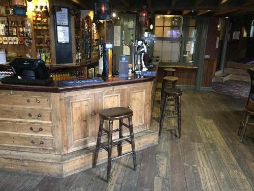 a bar with two stools sitting at a counter at The Kings Arms Hotel in Chipping Norton