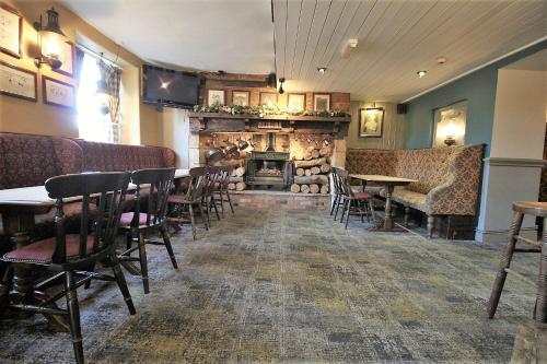 a restaurant with a fireplace and tables and chairs at The Kings Arms Hotel in Chipping Norton