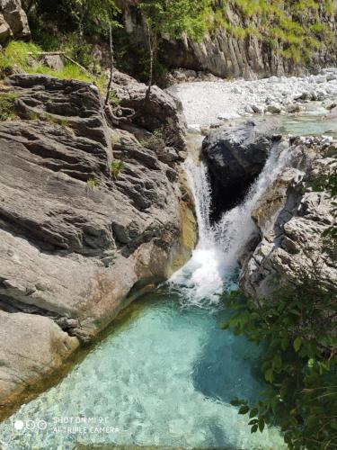 a waterfall in a river with a pool of water at Incantevole casa sul fiume, Relax e Natura ai piedi della Alpi Apuane in Massa