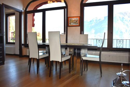 a dining room with a table and chairs and windows at BELLAGIO LAKESIDE APARTMENT in Bellagio