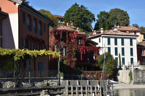 a building with ivy on it next to a river at BELLAGIO LAKESIDE APARTMENT in Bellagio