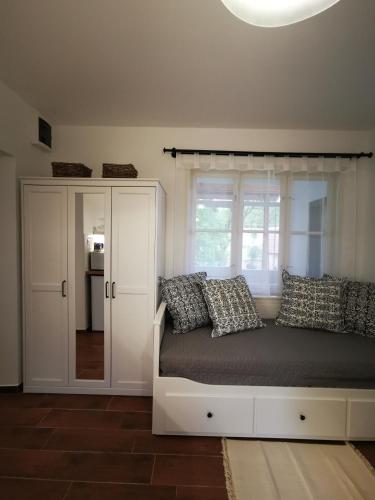 a bedroom with a bed and a window at Hűvösvölgy Vendégház in Lókút