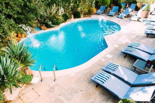 een zwembad met ligstoelen en een zwembad bij The Club Hotel & Spa Jersey in Saint Helier Jersey
