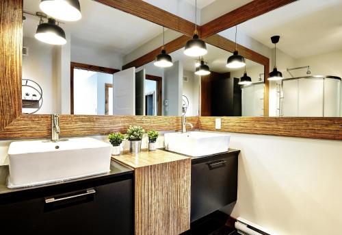Un baño con dos lavabos y un espejo grande. en Le Sto Shack 25 Chemin Blanc by Les Chalets Alpins, en Stoneham