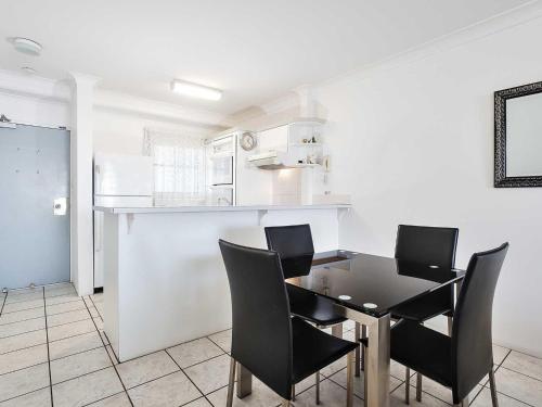 a dining room with a table and black chairs at Nelson Towers, 9,71a Victoria Parade - unit in the heart of Nelson Bay with water views, air conditioning and Wi-Fi in Nelson Bay