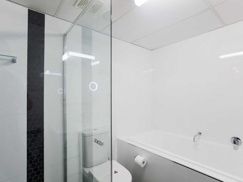 a glass shower in a bathroom with a toilet at Nelson Towers, 9,71a Victoria Parade - unit in the heart of Nelson Bay with water views, air conditioning and Wi-Fi in Nelson Bay