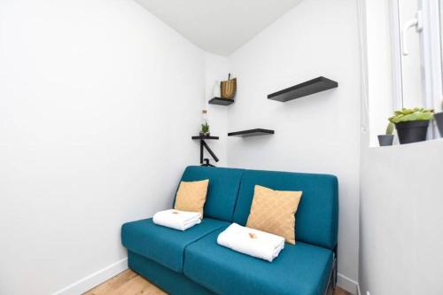 un divano blu in una stanza con pareti bianche di Cosy Studio / Dugommier a Parigi
