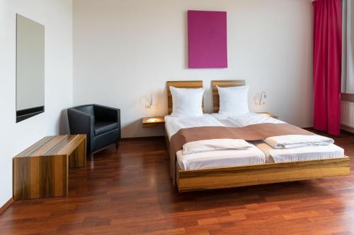 a bedroom with two beds and a flat screen tv at AMH Airport-Messe-Hotel Stuttgart in Filderstadt