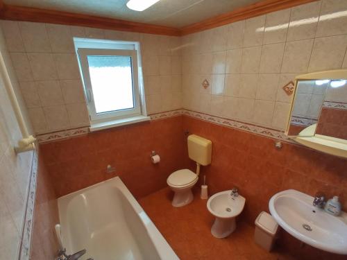 a bathroom with a tub and a toilet and a sink at ANKARAN SOBE MARA in Ankaran