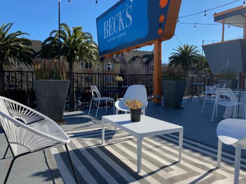 a patio with white chairs and tables and a sign at Beck's Motor Lodge in San Francisco
