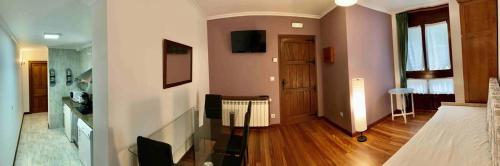 a room with a bed and a hallway with a television at Apartamentos La Posada de Abanillas in Abanillas