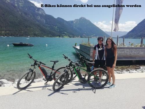 a man and a woman standing next to bikes on a beach at Denggnhof in Münster