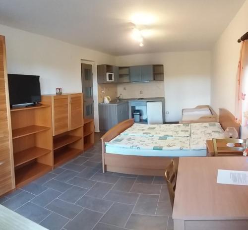 a bedroom with a large bed and a kitchen at Penzion Panter in Horní Planá