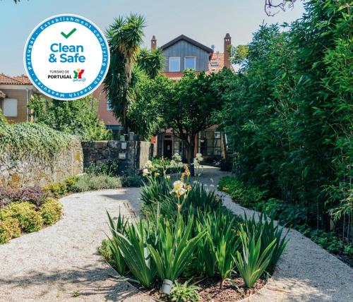a sign that reads clean and safe in front of a garden at Queen's Garden Hostel in Porto