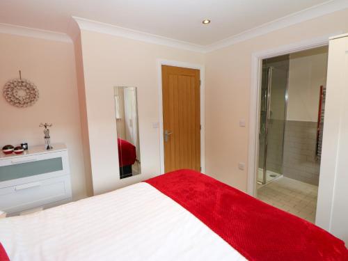 a bedroom with a bed with a red blanket at Broken-Sky Lodge in Newcastle upon Tyne