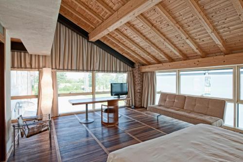 a bedroom with a bed and a couch and a table at Hotel Veronesi La Torre in Dossobuono