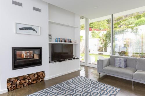 a living room with a fireplace and a tv at My Angra Charming House in Angra do Heroísmo