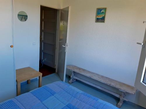 - une chambre avec un lit bleu et un banc dans l'établissement Séjour zen entre océan et forêt, à Seignosse