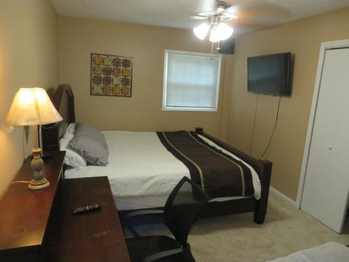 a bedroom with a bed and a desk and a television at Atlanta Hartsfield Airport Guesthouse - Netflix Disney Amzn in College Park