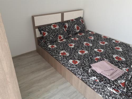 Schlafzimmer mit einem Bett mit einer schwarzen und roten Blumenbettdecke in der Unterkunft Luxury Beta in Mangalia