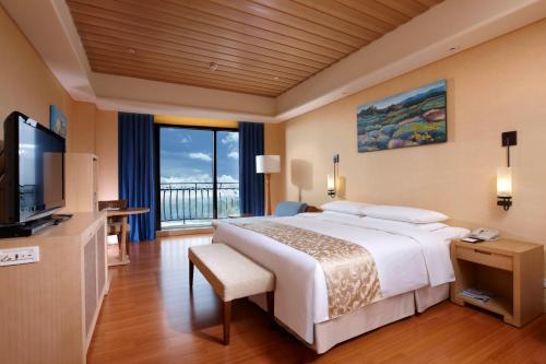 a hotel room with a large bed and a television at E-DA Royal Hotel in Dashu