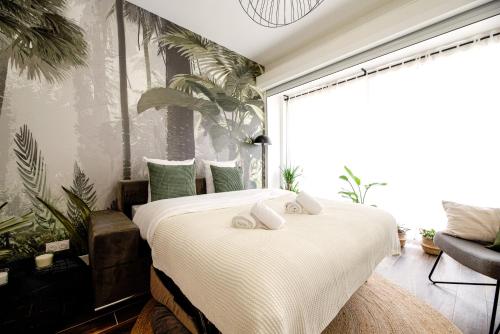 - une chambre avec un grand lit recouvert de plantes dans l'établissement Luxury home near Tour Eiffel, à Paris