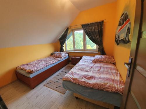 sypialnia z 2 łóżkami i oknem w obiekcie Dom nad Jeziorem Rożnowskim w mieście Tęgoborze