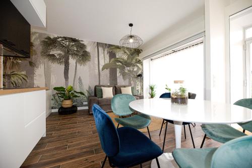- un salon avec une table blanche et des chaises bleues dans l'établissement Luxury home near Tour Eiffel, à Paris