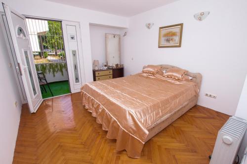 a bedroom with a bed and a wooden floor at Lea Apartment in Bar