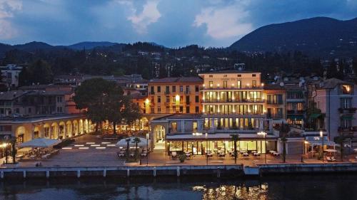 a large body of water with a large building at Hotel Du Lac in Gardone Riviera