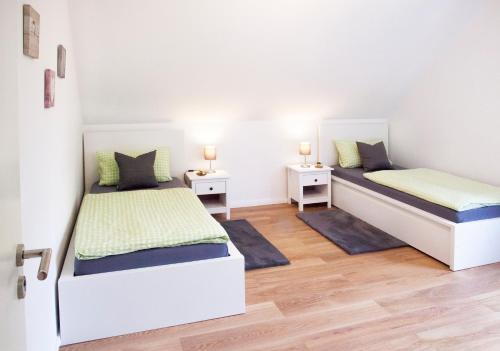 a bedroom with two beds and two night stands at FeWo Nelly Marie Wohnung Nelly in Hademstorf