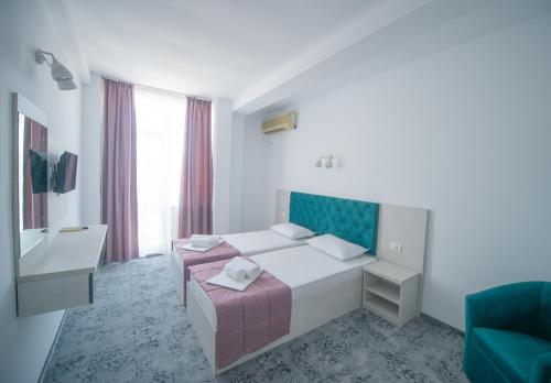 Un pat sau paturi într-o cameră la Hotel Olguta