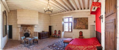 1 dormitorio con cama roja y chimenea en Le Chatelet Thilouze, en Thilouze