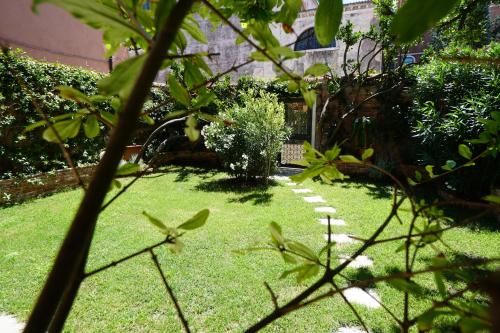 a garden with green grass and plants and a building at P 1779 in Venice